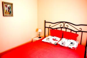 1 dormitorio con cama roja y almohadas rojas en Los Naranjos en Guardamar del Segura