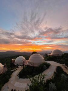 two yurt domes with a sunset in the background at Kintiri Glamping in Nicoya
