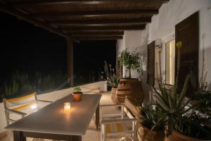 a table and chairs on a patio with plants at Lotos Beach Home in Kini