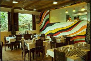 a restaurant with tables and chairs and a colorful wall at Angelina Beach Resort & Italian Restaurant Malapascua in Malapascua Island +72 photos