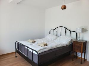 1 dormitorio con 1 cama con sábanas blancas y mesa en Nad Dąbrówką, en Mała Huta