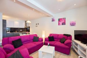 a living room with a purple couch and a tv at STIGA 1 - new ap. 4 two in Prožura