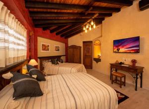 a bedroom with two beds with cats laying on them at La Casona Colorada San Felipe del Agua in Oaxaca City