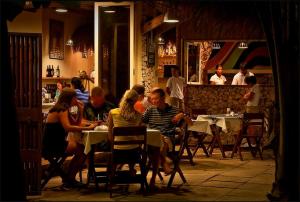a group of people sitting at a table in a restaurant at Angelina Beach Resort & Italian Restaurant Malapascua in Malapascua Island