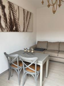 a table and chairs in a living room with a couch at 3 MINUTI A PIEDI DAL MARE parking & wifi included FIUMARETTA , in Fiumaretta di Ameglia