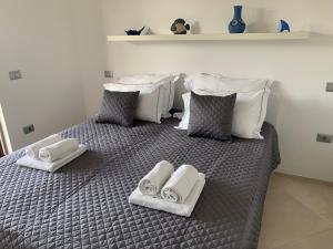 łóżko z białymi ręcznikami i poduszkami w obiekcie Sea Star Apartment w Koprze