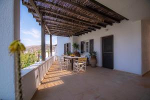 a balcony of a house with a table and chairs at Lotos Beach Home in Kini