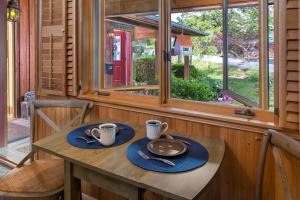 a wooden table with two cups and plates on it at Eureka Sunset Cabins in Eureka Springs