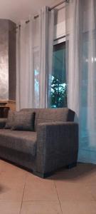 a couch sitting in front of a window with curtains at Seaside Deluxe Apartment in Skala Kallirachis