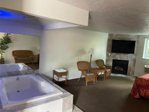 a living room with a large tub and a fireplace at VIBE INN - WHIRLPOOLS SUITES - Lyons in Lyons