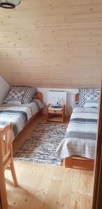 Dos camas en una habitación con paredes de madera. en Willa Basinek, en Muszyna