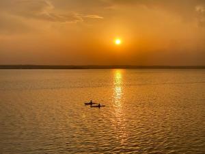 two people in a boat on the water at sunset at Deluxe Criss Solid Residence Mamaia in Mamaia +20 photos