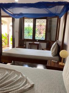 a bedroom with a bed and a canopy at Highland Bungalows in Nungwi