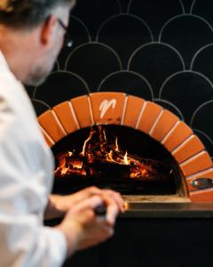 a man standing in front of a brick oven at Calistoga Motor Lodge and Spa, a JdV by Hyatt Hotel in Calistoga