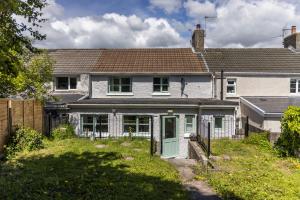 una casa blanca con una puerta verde en Inglenook Cottage near Porthcawl and Beaches, en North Cornelly