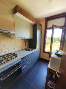 a kitchen with a stove and a sink and a window at T1 Troia Resort - Praia Mar in Comporta