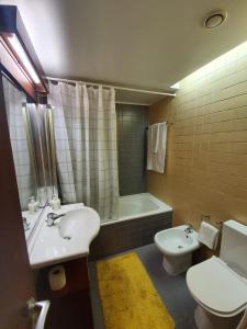 La salle de bains est pourvue d'un lavabo, de toilettes et d'une baignoire. dans l'établissement T1 Troia Resort - Praia Mar, à Comporta