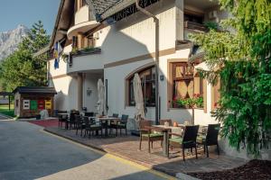 a patio with tables and chairs in front of a building at Garni Hotel Miklič in Kranjska Gora