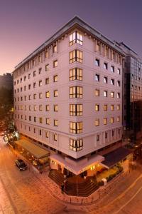 duży biały budynek przy ulicy miejskiej w obiekcie Nippon Hotel w Stambule