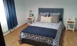a bedroom with a bed with a blue and white comforter at Família Gaiolas in Marinhais