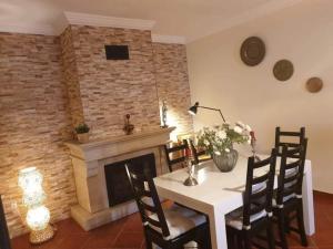 a dining room with a table and a fireplace at Família Gaiolas in Marinhais