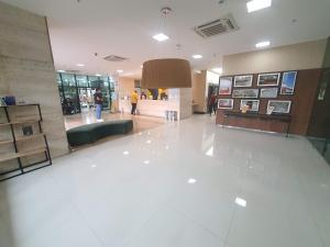 un hall avec un grand sol blanc et des gens qui y marchent dans l'établissement Flat no Athos Bulcão Executive By Rei dos Flats, à Brasilia 29 autres photos