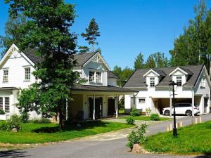 a white house with a car parked in the driveway at Holiday home RIMBO II in Rimbo