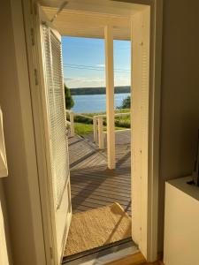 una puerta abierta a un porche con vistas al agua en Ilmola resort by the river en Keminmaa