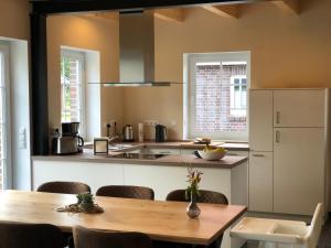 a kitchen with a wooden table and a counter top at Dat Ankerhuus Timmel in Großefehn 