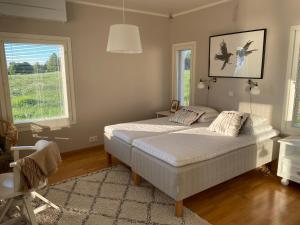a bedroom with a bed and two windows at Ilmola resort by the river in Keminmaa