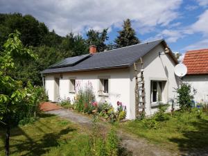 un cottage blanc avec un toit noir dans l'établissement Pochebachhäusl, à Jonsdorf