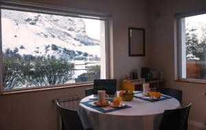 a table in a room with a view of a mountain at Aguila Mora Aparts in El Chalten +26 photos