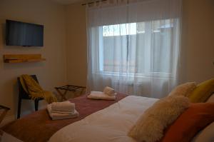a bedroom with a bed with towels on it at Aguila Mora Aparts in El Chalten
