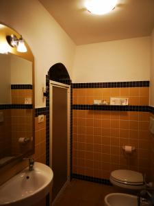 a bathroom with a sink and a toilet and a mirror at B&B Corti Carmela in Gallipoli