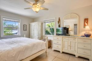 a bedroom with a bed and a tv and a mirror at Beachfront Ocean Duplex in Layton
