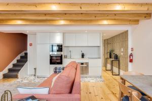 een woonkamer met een bank en een keuken bij Hopstays Oporto Tiles 2 - City Center Duplex in Porto