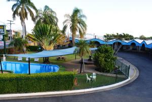 a view of a resort with a pool and palm trees at David Motor Inn in Rockhampton