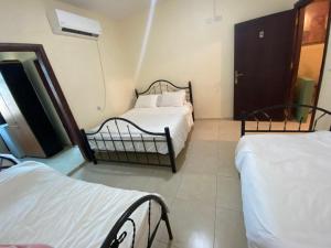 a bedroom with two beds in a room with a window at Jericho Waleed's Hostel in Jericho