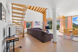 a living room with a couch and a staircase at Golden Peaks Ferienhaus Valbella-Lenzerheide in Valbella