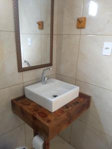 a bathroom with a white sink and a mirror at Chalés Manacá da Serra in Urubici