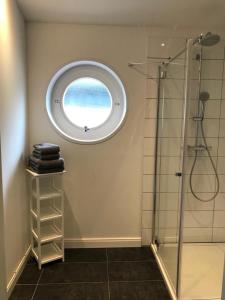 a bathroom with a shower and a round window at Wellenzauber - Haus 19 in Grömitz