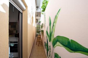 un couloir orné d'une fresque murale représentant des plantes dans l'établissement Budva Apartment Nadja, à Budva