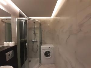 a bathroom with a shower and a washing machine at Apartament na Warszawskiej in Gdynia