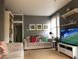 sala de estar con sofá y TV en Wimbledon fortnight, en Londres