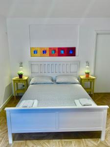 a large white bed with a white headboard in a room at Fafà Apartment in Naples