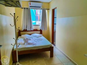 a small bedroom with a bed with a window at Hotel dos Devotos in Aparecida +41 photos