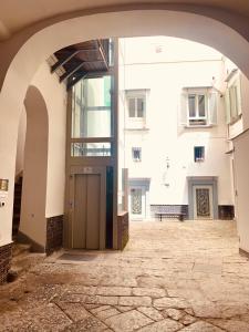 une arche menant à un bâtiment avec une porte dans l'établissement Fafà Apartment, à Naples