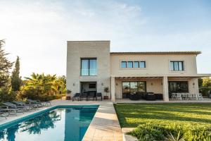 ein Haus mit einem Swimmingpool vor einem Haus in der Unterkunft Villa Can Paulo in Santanyi