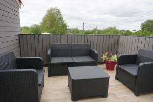 eine Terrasse mit Stühlen, Tischen und einem Zaun in der Unterkunft Appart Cosy 4 personnes avec terrasse in La Roche-sur-Yon