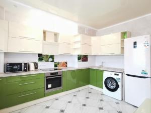 una cocina verde con electrodomésticos blancos y armarios verdes en Manufactura luxery apartments en Sumy